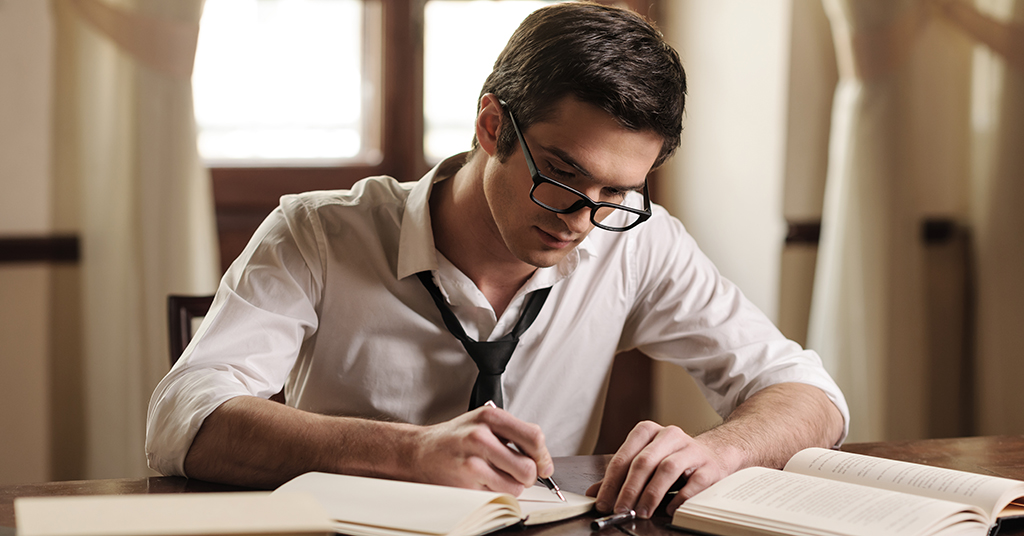 man writing books