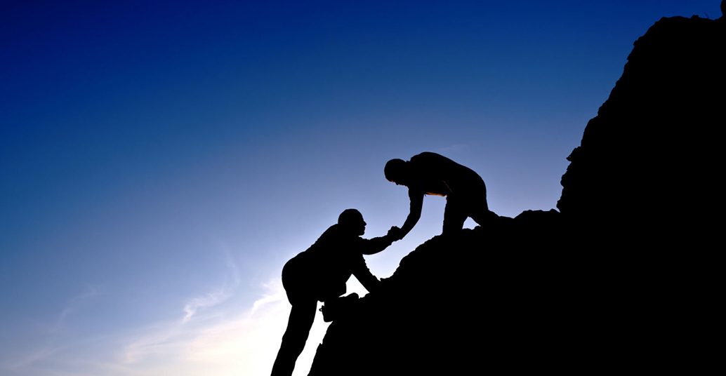 man helping his friend climb